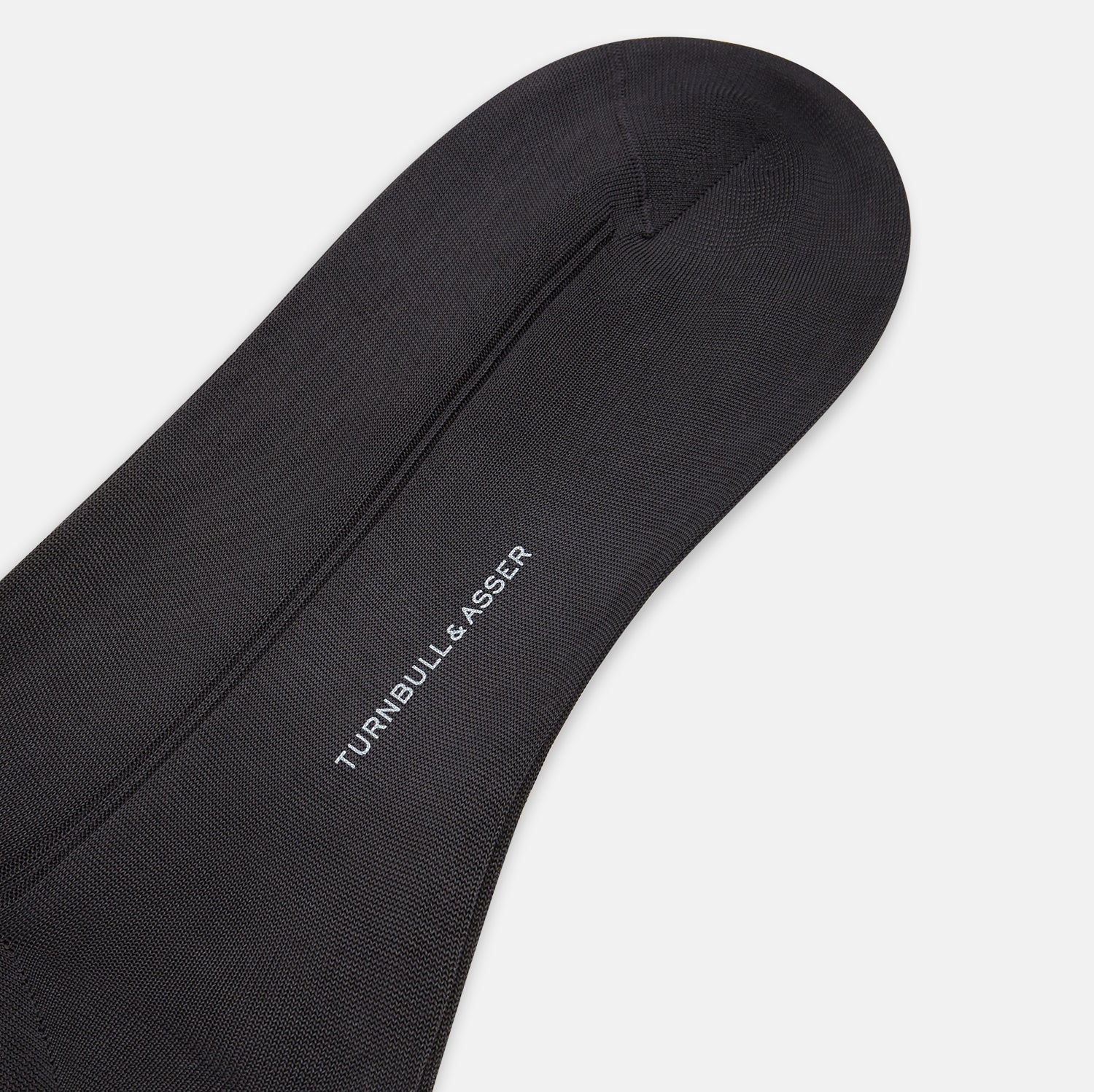 View 3 of product A single Sage Silk Long Sock by Turnbull & Asser, in black, is displayed from a side angle against a plain white background.