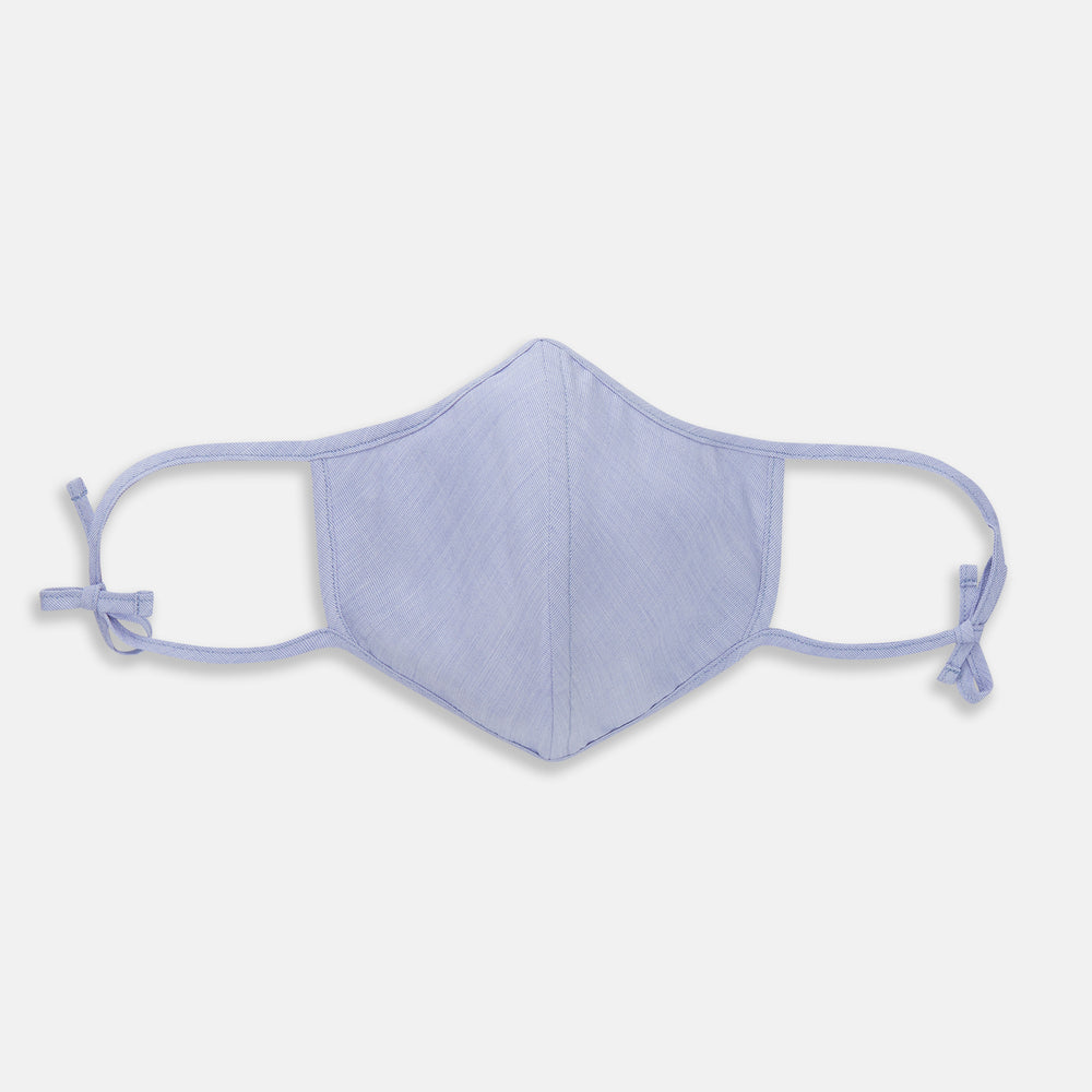 The Turnbull & Asser Plain Pale Blue Commuter Mask with 3 Viroformula™ filters features adjustable ear loops and side ties—ideal for daily use, shown against a white background.