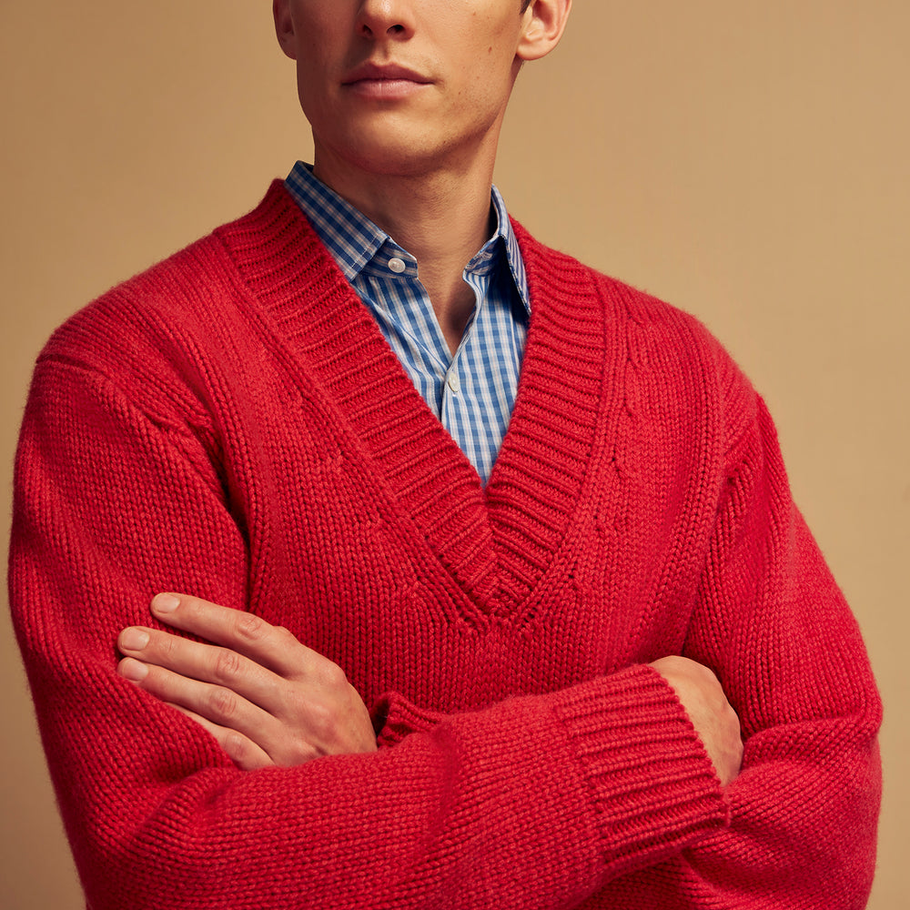 The Turnbull & Asser Raspberry Red Cashmere Edwards V-Neck Sweater features long sleeves, ribbed cuffs and hem, and is shown laid flat on a white background.