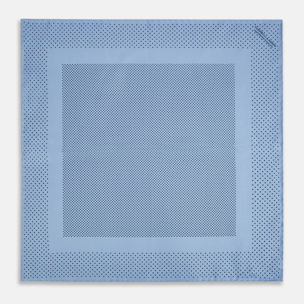 The Turnbull & Asser Pale Blue Dot Silk Pocket Square features pure silk in pale blue with a border and scattered small navy polka dots, neatly folded with one corner turned down.