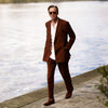 View 4 of product Turnbull & Asser’s Rust Linen-Wool-Silk Gerry Trousers, in a classic fit with straight legs, pleats, belt loops, and front button-zip closure, are neatly displayed flat on a white background.