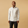 View 1 of product A man wears the Turnbull & Asser Yellow Multi Blazer Stripe Weekend Fit Suffolk Shirt, standing against a beige background with his hands relaxed—a casual look perfect for weekends.