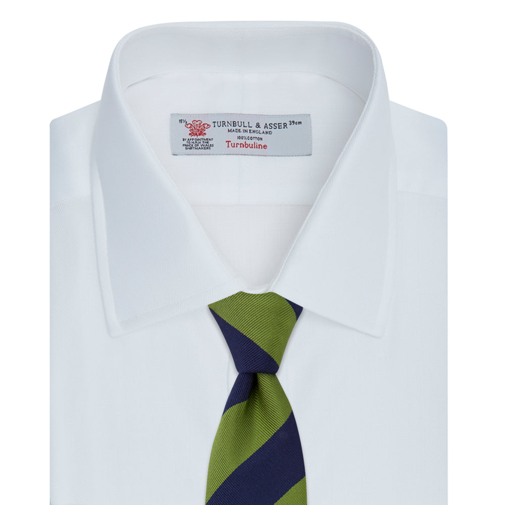 The Turnbull & Asser White Herringbone Superfine Cotton Shirt features a T&A collar, double cuffs, and a visible label inside the collar, shown neatly folded on a light blue background—ideal for minimalist looks or pairing with bold ties.