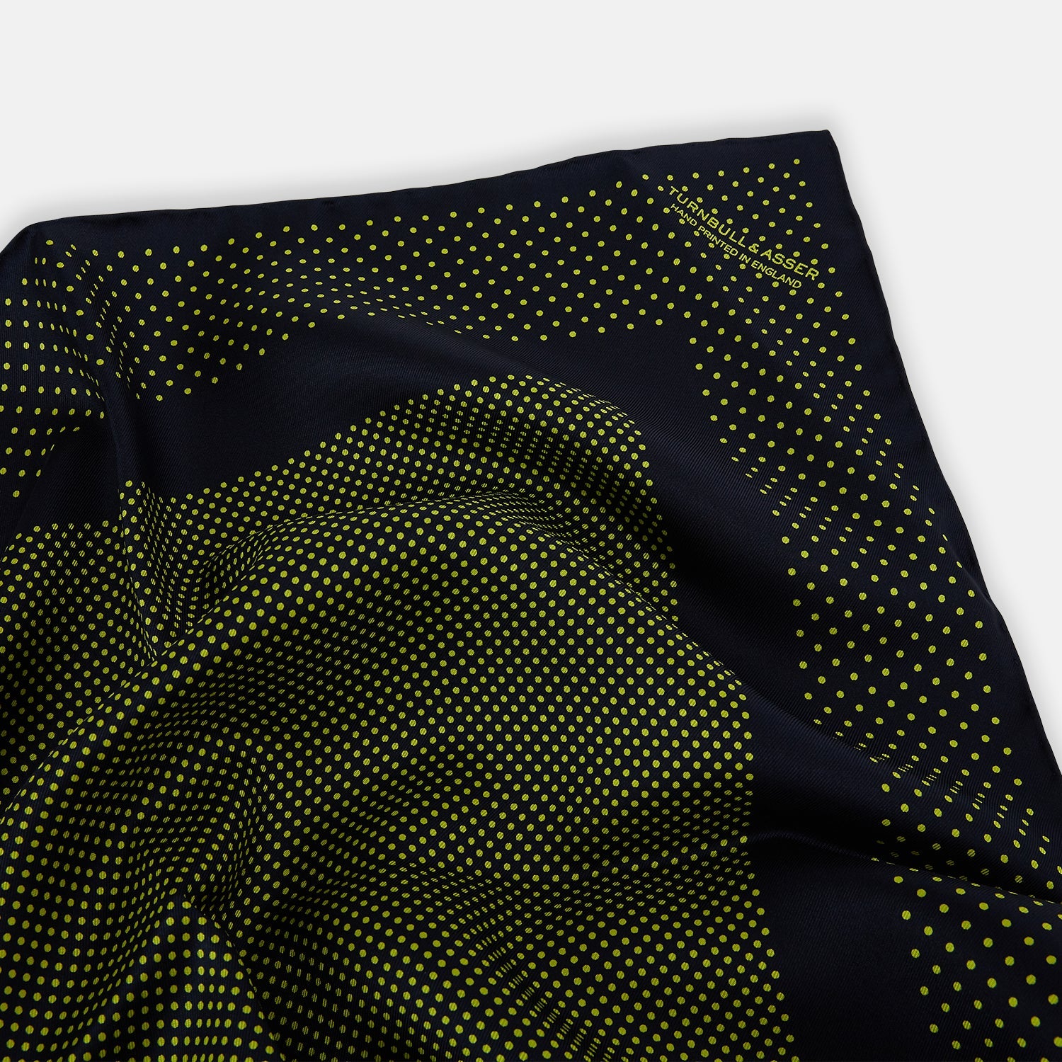 View 2 of product The Turnbull & Asser Navy and Yellow Dot Silk Pocket Square features a navy base with yellow dots, a solid navy border, and a folded corner showing the patterned underside for an elegant accent.