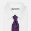 View 2 of product The HORIZONTAL TWILL PLUM TIE by Turnbull & Asser features a solid purple hue and smooth, subtly textured fabric—a versatile accessory to elevate any wardrobe, shown elegantly against a white background.
