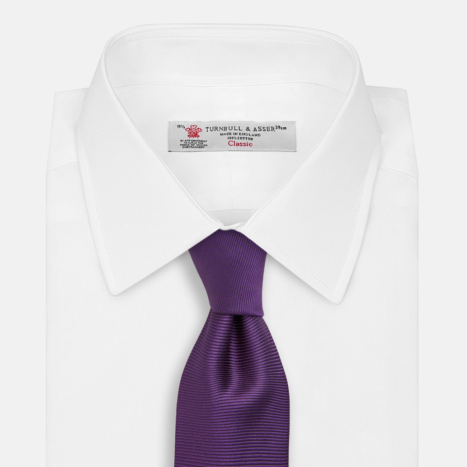 View 2 of product The HORIZONTAL TWILL PLUM TIE by Turnbull & Asser features a solid purple hue and smooth, subtly textured fabric—a versatile accessory to elevate any wardrobe, shown elegantly against a white background.