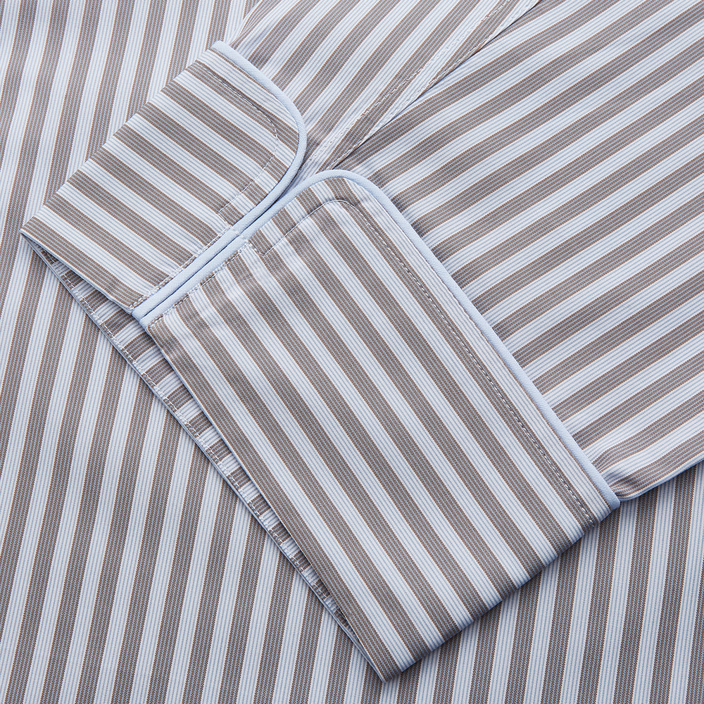The Turnbull & Asser Pale Blue Multi Stripe Cotton Quin Pyjamas, featuring a long-sleeve button-up top and matching adjustable tie-waist pants, are neatly arranged on a white background.