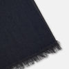 View 2 of product The Charcoal and Navy Cashmere Scarf by Turnbull & Asser features a color block design in dark hues, raw fringed edges, and a soft, smooth texture, elegantly displayed against a white background.