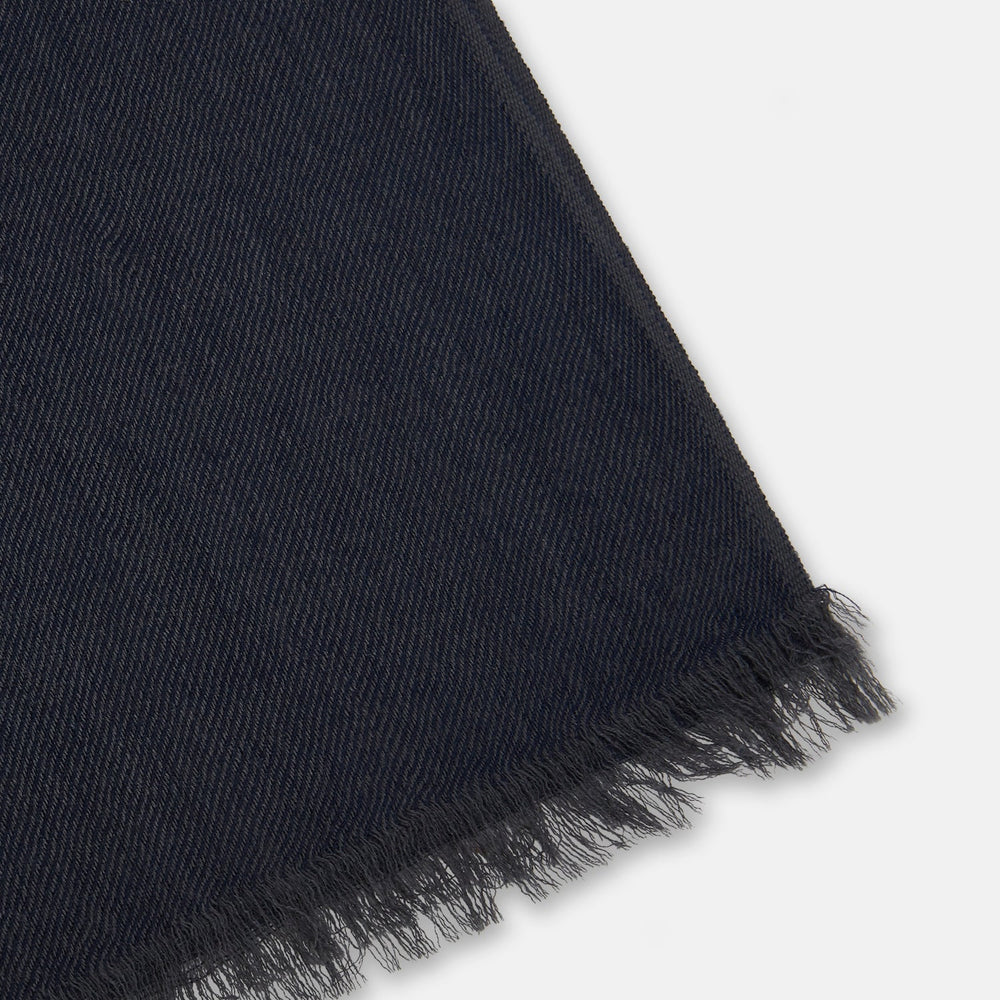 The Charcoal and Navy Cashmere Scarf by Turnbull & Asser features a color block design in dark hues, raw fringed edges, and a soft, smooth texture, elegantly displayed against a white background.
