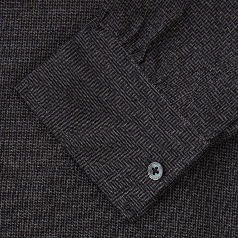 A man with short hair wears the Turnbull & Asser Black Check Weekend Fit Flannel Shirt with Derby Collar and 1-Button Cuffs, paired with light pants, against a plain background—ideal for a smart-casual weekend look.