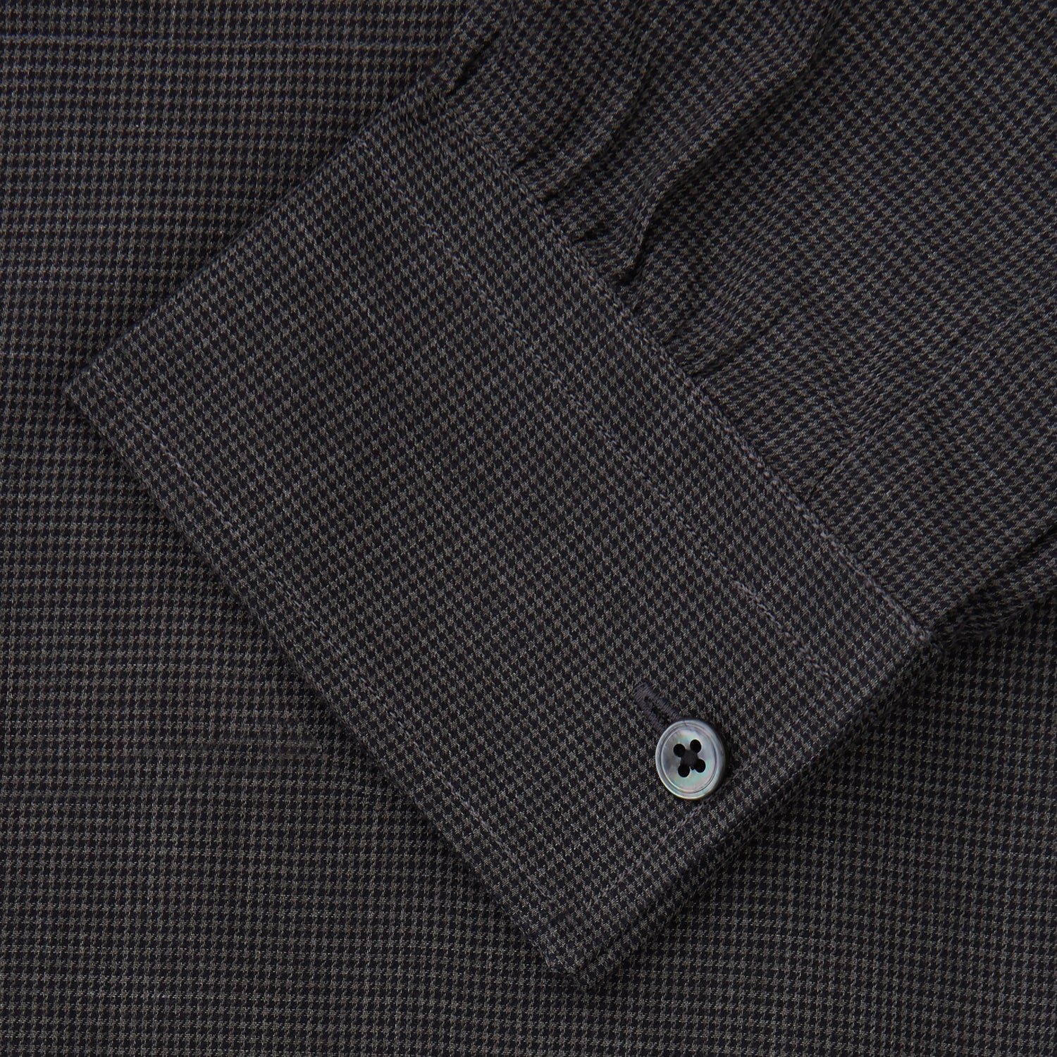 View 4 of product A man with short hair wears the Turnbull & Asser Black Check Weekend Fit Flannel Shirt with Derby Collar and 1-Button Cuffs, paired with light pants, against a plain background—ideal for a smart-casual weekend look.
