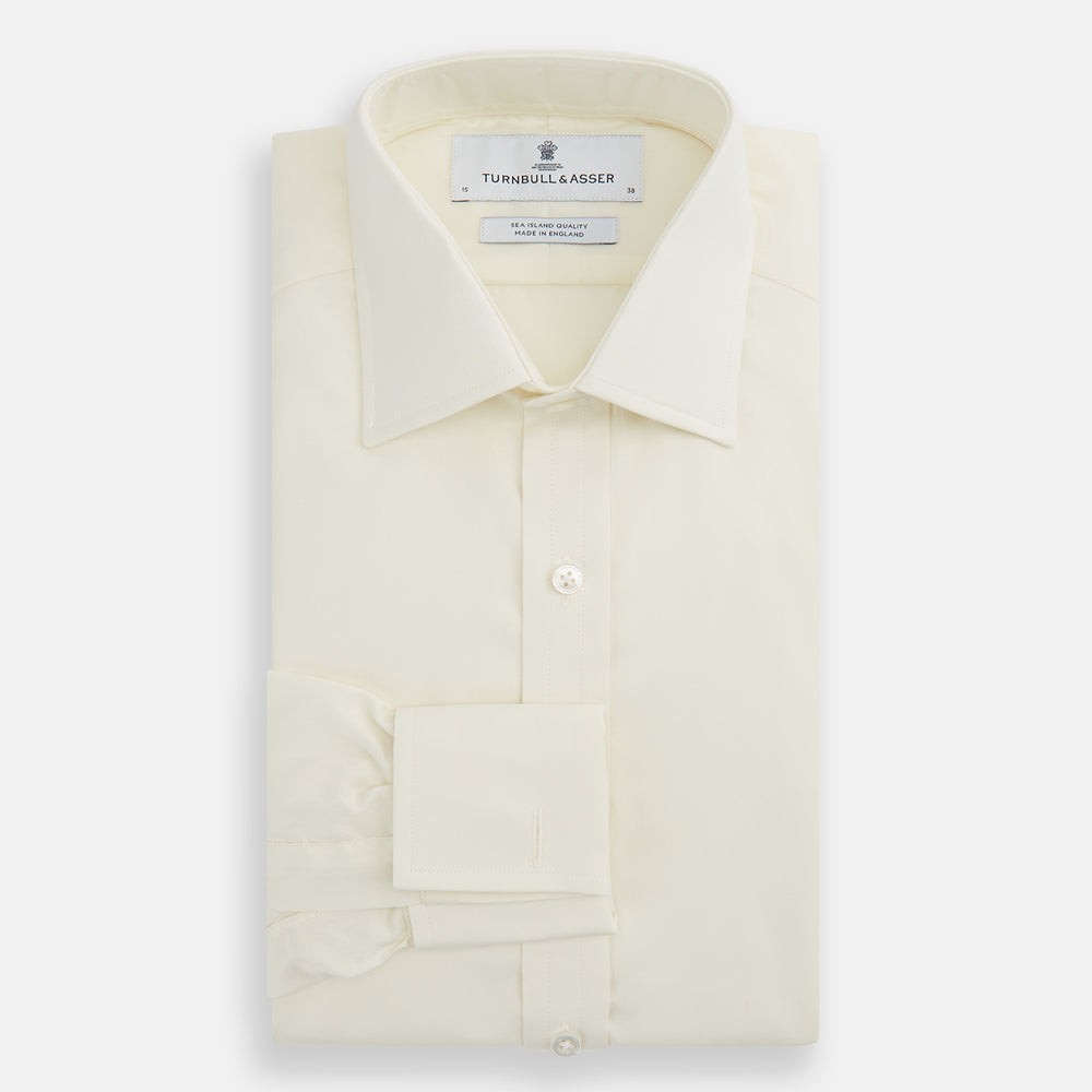 The Tomorrow Never Dies Cream Cotton Hamburg Shirt by Turnbull & Asser is a classic, cream-colored, long-sleeved button-up with a traditional collar and buttoned cuffs—just like the one worn by James Bond.