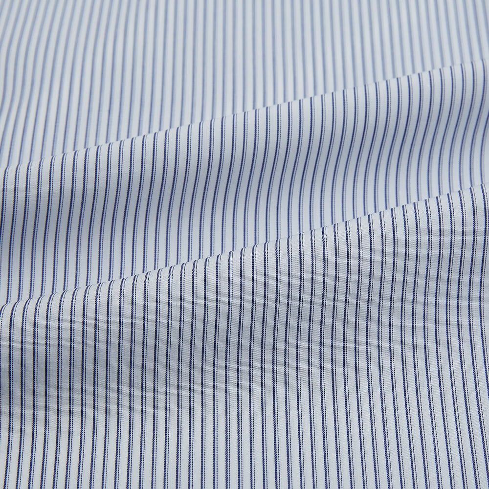 The Navy and White Ticking Stripe Mayfair Shirt by Turnbull & Asser features long sleeves, buttoned cuffs, a pointed T&A collar, and button-up front, shown on a plain white background.