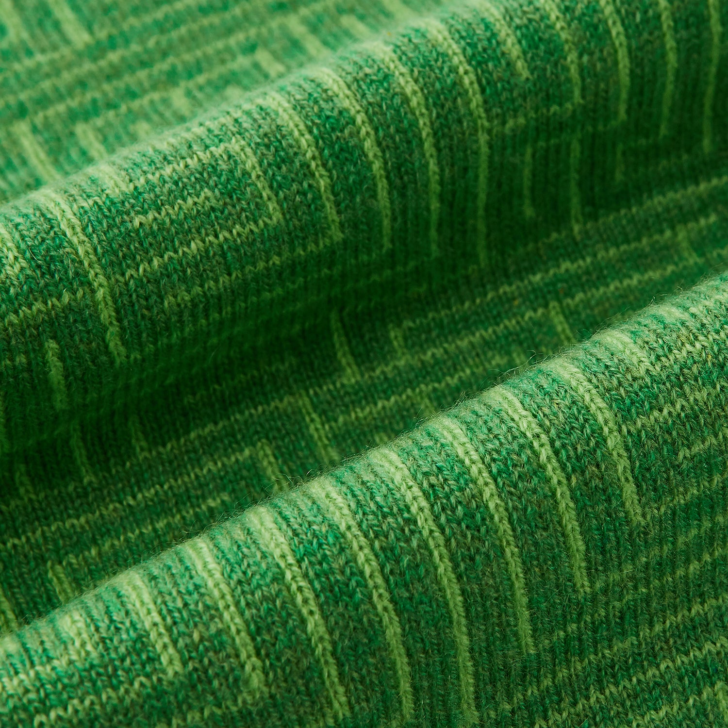 View 3 of product The Turnbull & Asser Kelly Green Fretwork Cashmere Knitted Scarf features a subtle, intricate pattern and is neatly knotted against a plain white background—an elegant accessory for any occasion.