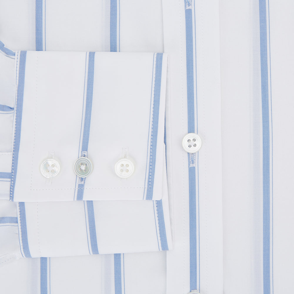 The Colony Blue Track Stripe Mayfair Shirt by Turnbull & Asser is a long-sleeve, button-up Italian cotton shirt with a white base and blue stripes, pointed collar, and buttoned cuffs, shown laid flat on a white background.