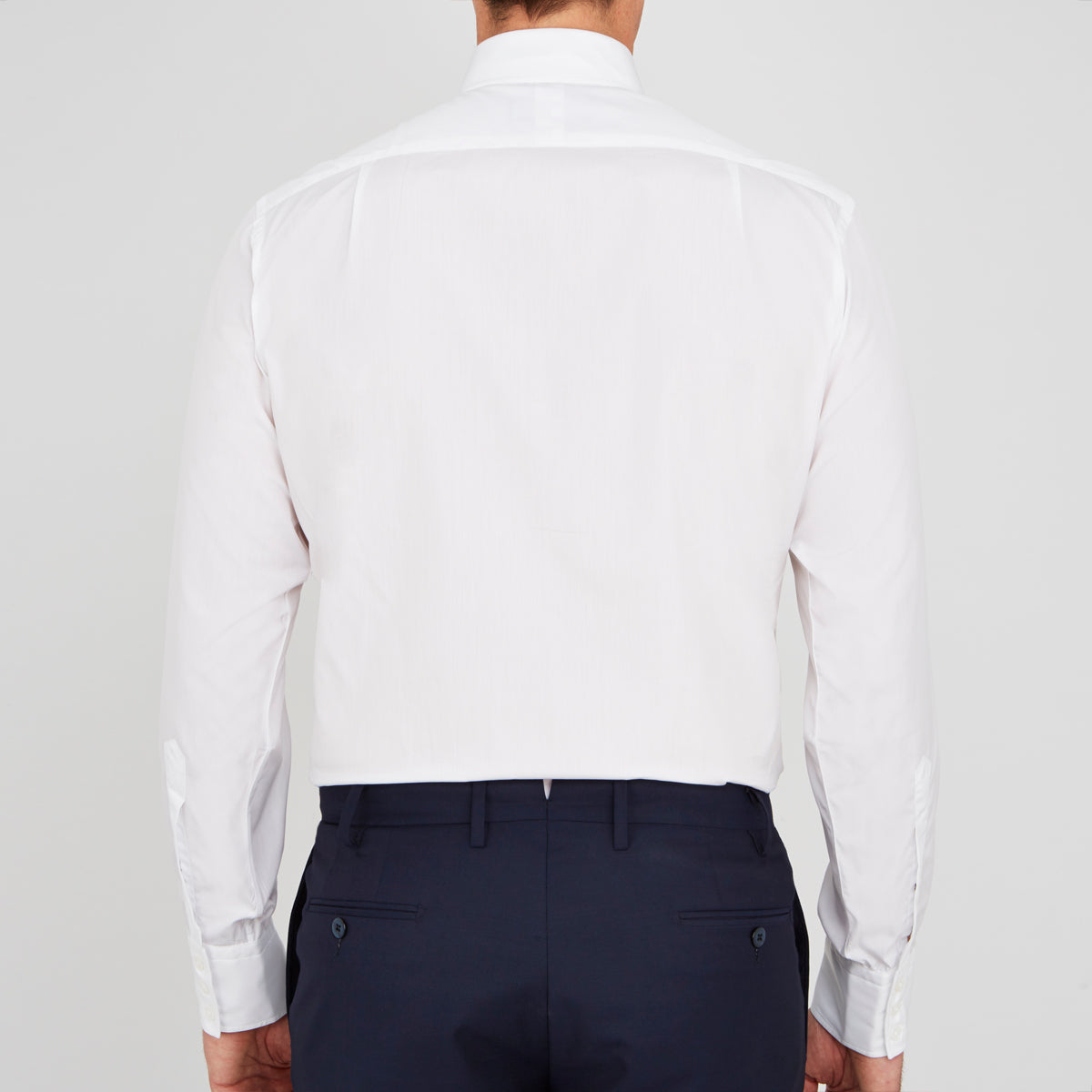View 3 of product A neatly folded Turnbull & Asser Two-Fold 200 White Cotton Shirt with a Regent collar and 3-button cuffs, crafted from breathable fabric, is displayed on a light grey background with the label visible inside the collar.