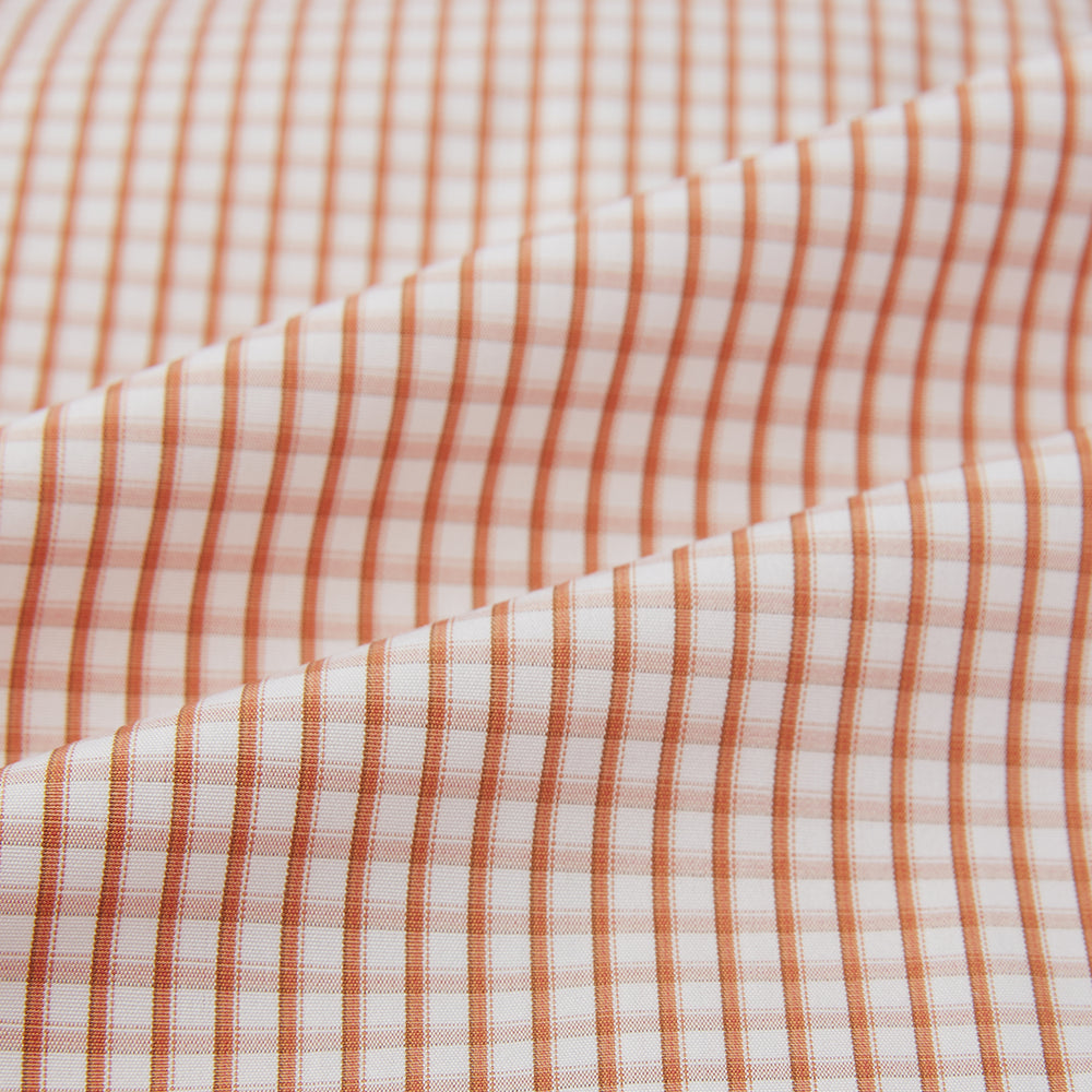 The Orange Micro Shadow Check Mayfair Shirt by Turnbull & Asser features a T&A collar, button-down front, and buttoned cuffs; crafted from Italian cotton in an orange and white check pattern, laid flat on a white background.