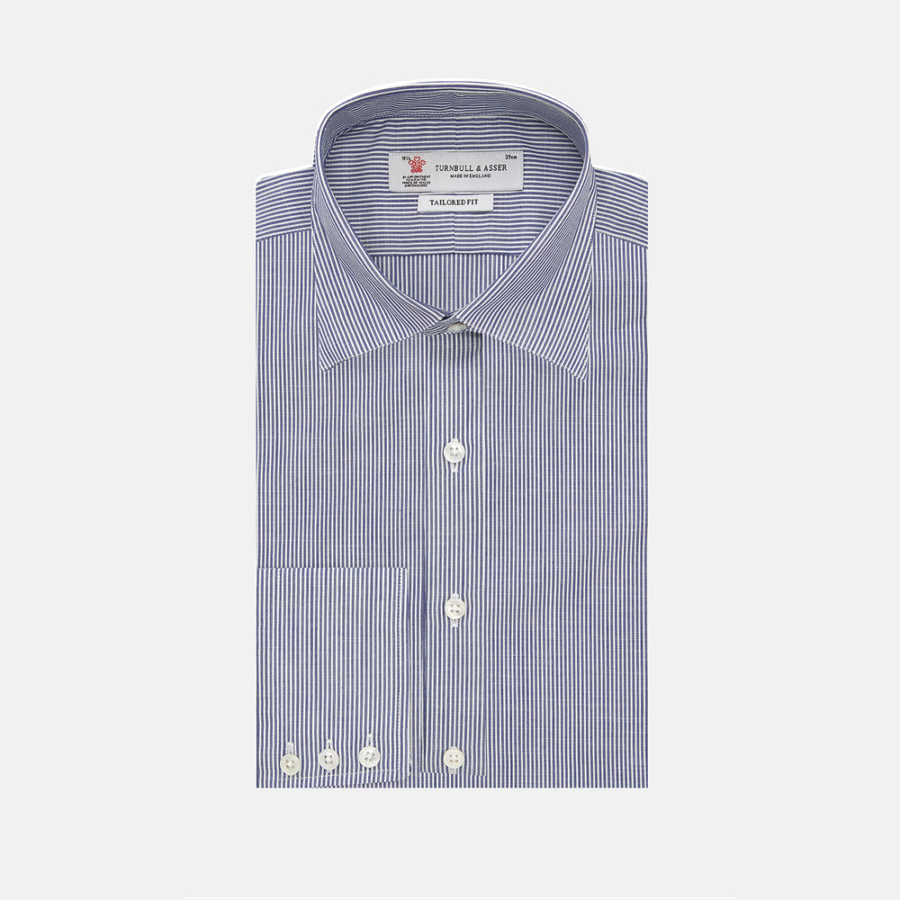 The Turnbull & Asser Navy and White Bengal Stripe Tailored Fit Shirt features blue and white vertical stripes, white buttons, and a streamlined silhouette, shown neatly folded against a plain white background.