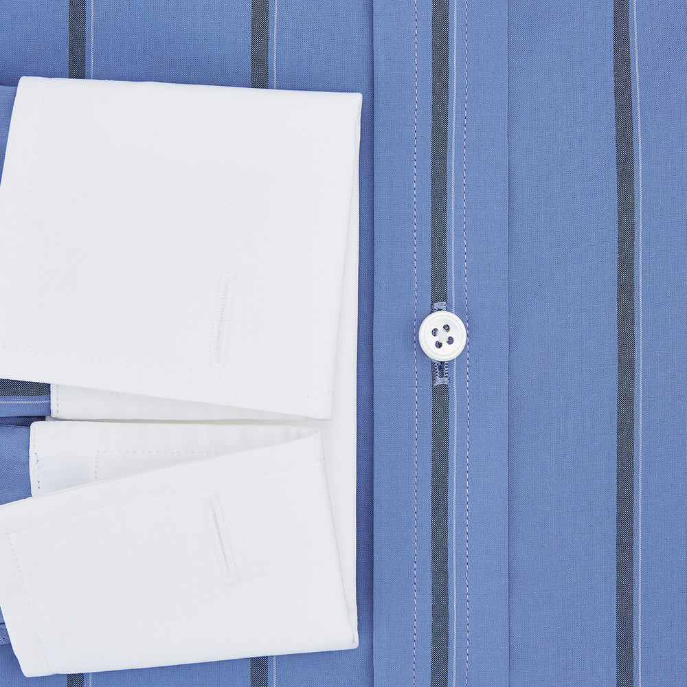 The Turnbull & Asser Colony Blue Track Stripe Shirt features vertical dark blue stripes, a Mayfair fit, and contrast white T&A collar and cuffs, reflecting British craftsmanship against a plain light background.