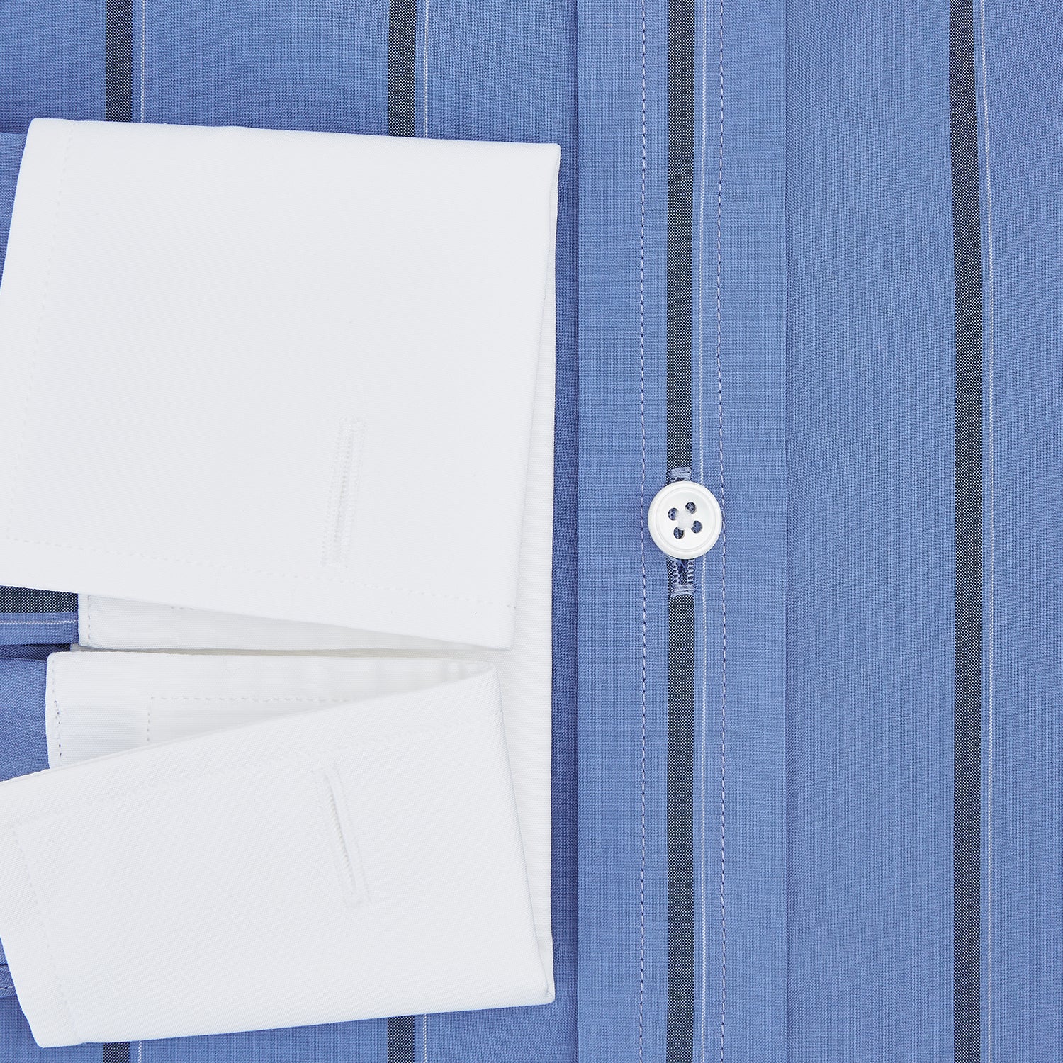 View 4 of product The Turnbull & Asser Colony Blue Track Stripe Shirt features vertical dark blue stripes, a Mayfair fit, and contrast white T&A collar and cuffs, reflecting British craftsmanship against a plain light background.