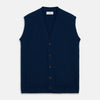 View 2 of product A man with a shaved head wears a Turnbull & Asser Navy Sleeveless Cashmere Cardigan over a white dress shirt with rolled-up sleeves and dark trousers, standing against a plain light gray background.