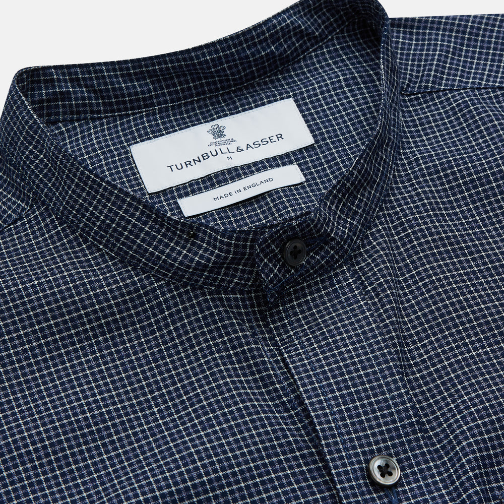 The Turnbull & Asser Navy Check Weekend Fit Flannel Shirt features a stand collar, button front, two chest pockets with flaps, and 1-button cuffs, crafted from soft Italian cotton and shown laid flat on a white background.
