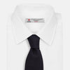 View 2 of product The GRENADINE NEW NAVY TIE by Turnbull & Asser features a dark navy blue woven texture, making it the perfect accessory for refined looks. Displayed against a plain white background.
