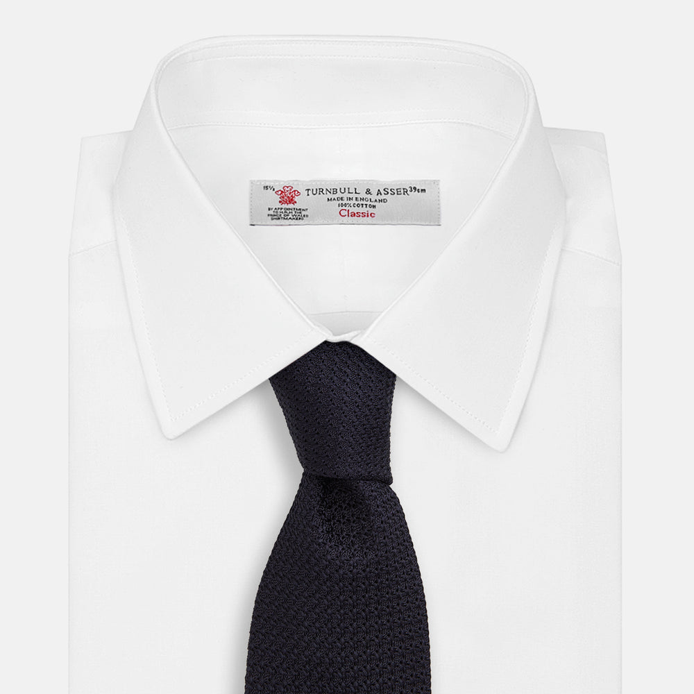 The GRENADINE NEW NAVY TIE by Turnbull & Asser features a dark navy blue woven texture, making it the perfect accessory for refined looks. Displayed against a plain white background.