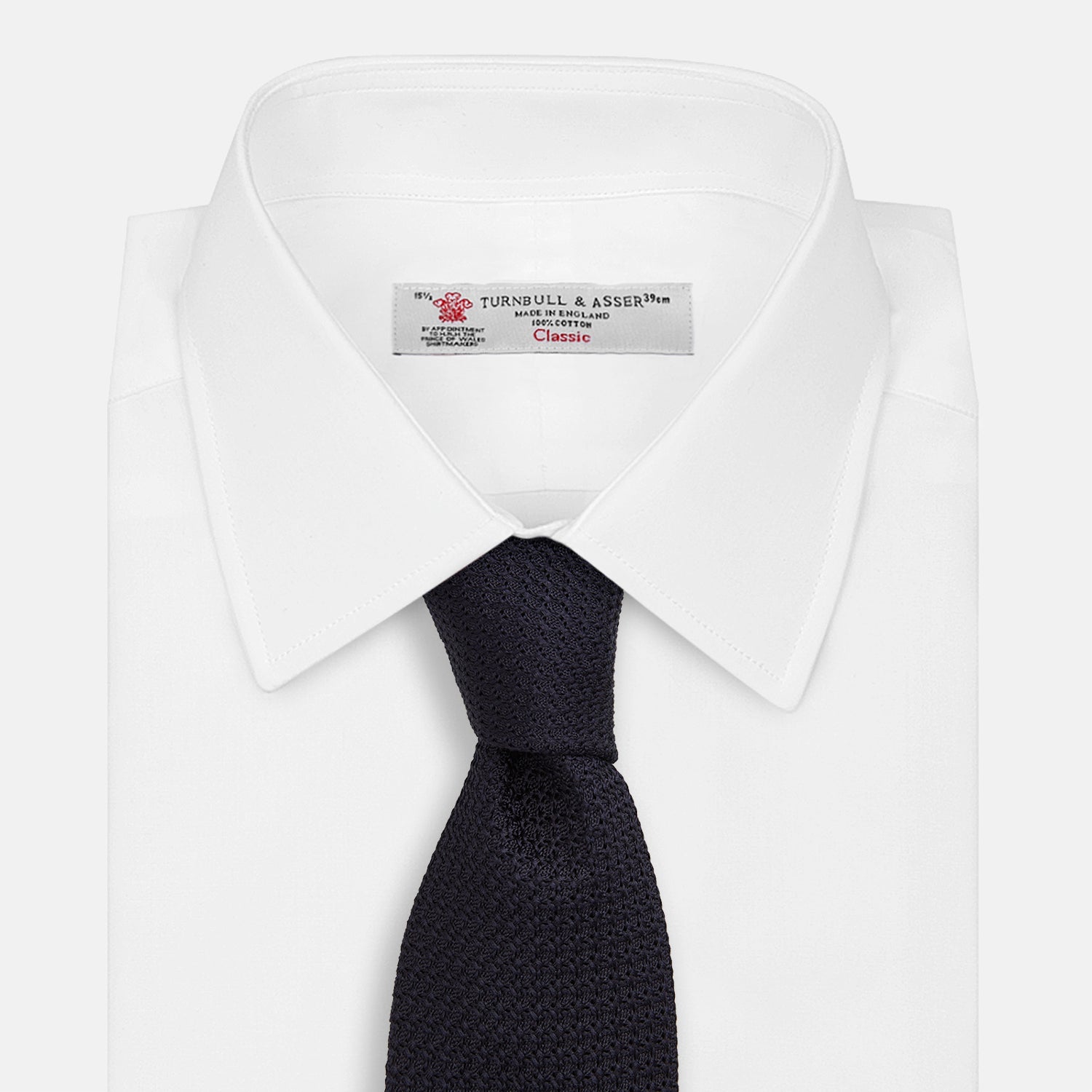 View 2 of product The GRENADINE NEW NAVY TIE by Turnbull & Asser features a dark navy blue woven texture, making it the perfect accessory for refined looks. Displayed against a plain white background.