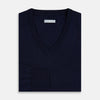 View 4 of product The Turnbull & Asser Navy Fine Merino V-Neck Jumper is displayed against a white background, featuring ribbed cuffs and hem for timeless style in a classic, plain long-sleeve design.
