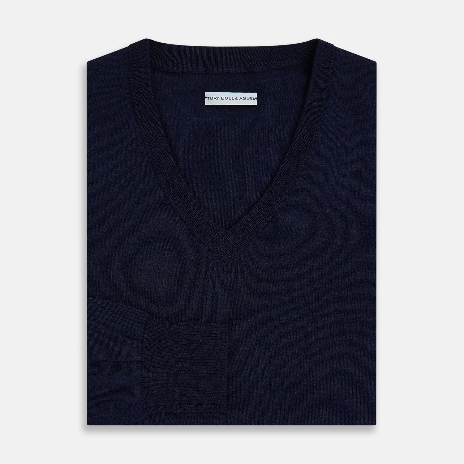 View 4 of product The Turnbull & Asser Navy Fine Merino V-Neck Jumper is displayed against a white background, featuring ribbed cuffs and hem for timeless style in a classic, plain long-sleeve design.