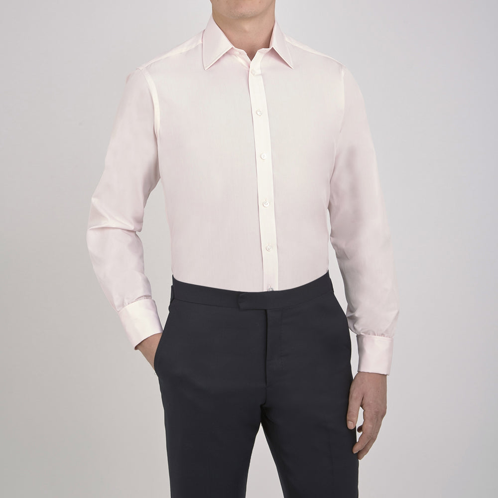 A neatly folded Pink Cotton Shirt with T&A collar and double cuffs by Turnbull & Asser, featuring a classic design with white buttons and an inner label, displayed on a plain white background.