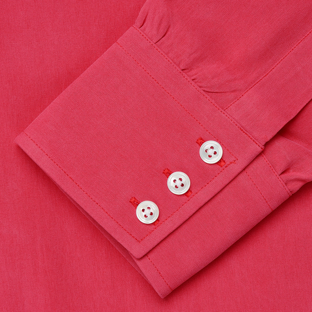 The Turnbull & Asser Coral Pink Silk Regular Fit Mayfair Shirt features long sleeves, a classic collar, and white buttons, displayed laid flat on a plain white background.