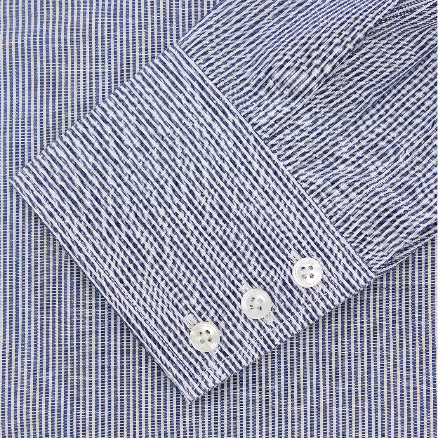 View 2 of product The Turnbull & Asser Navy and White Bengal Stripe Tailored Fit Shirt features blue and white vertical stripes, white buttons, and a streamlined silhouette, shown neatly folded against a plain white background.