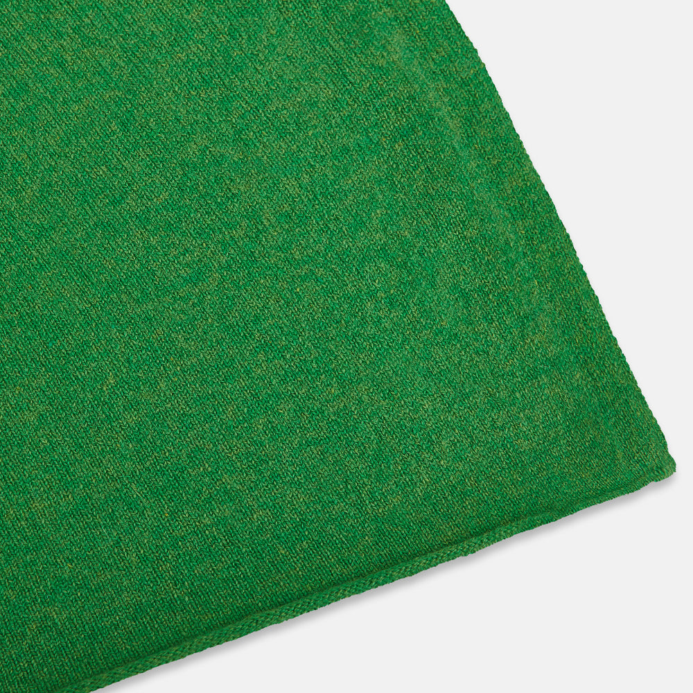 The Turnbull & Asser Plain Kelly Green Cashmere Knitted Scarf is shown looped at the top with both ends hanging down, its soft texture and vibrant color standing out against a plain white background.