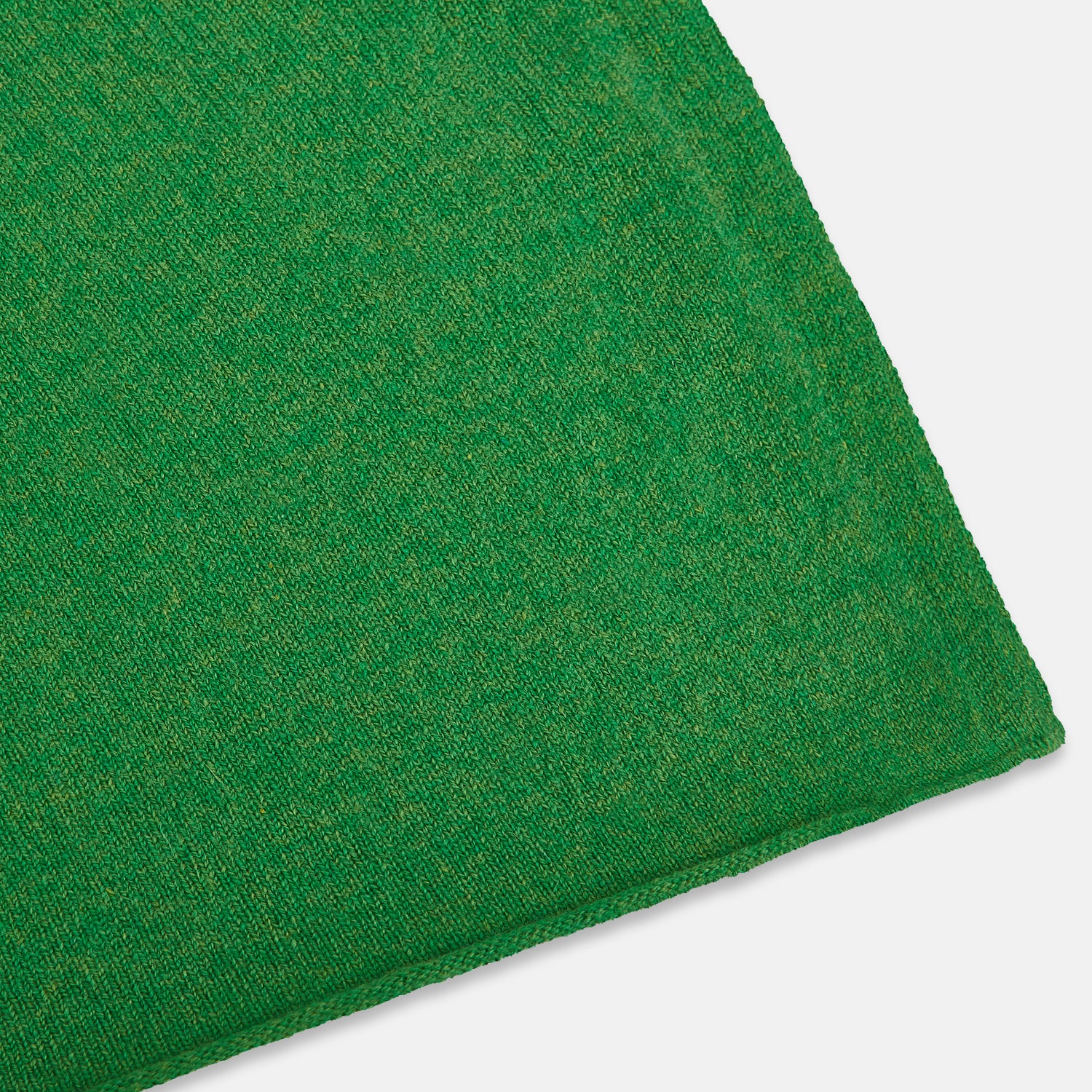 View 2 of product The Turnbull & Asser Plain Kelly Green Cashmere Knitted Scarf is shown looped at the top with both ends hanging down, its soft texture and vibrant color standing out against a plain white background.