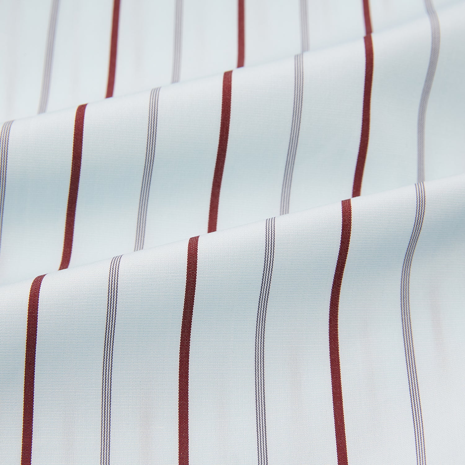 View 6 of product The Turnbull & Asser Burgundy Combination Stripe Mayfair Shirt features long sleeves, a classic T&A collar, and vertical black and burgundy stripes on white, laid flat against a plain white background.