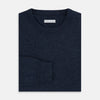 View 4 of product The Turnbull & Asser Midnight Blue Cashmere Round Neck Jumper, featuring long sleeves and ribbed trims, is shown against a light grey background.