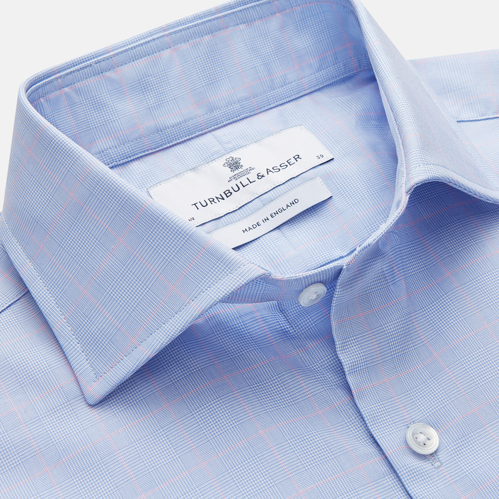 A Blue and Red Prince of Wales Check Mayfair Shirt by Turnbull & Asser, featuring long sleeves, a spread collar, buttoned cuffs, and button-up front, is laid flat on a white background.