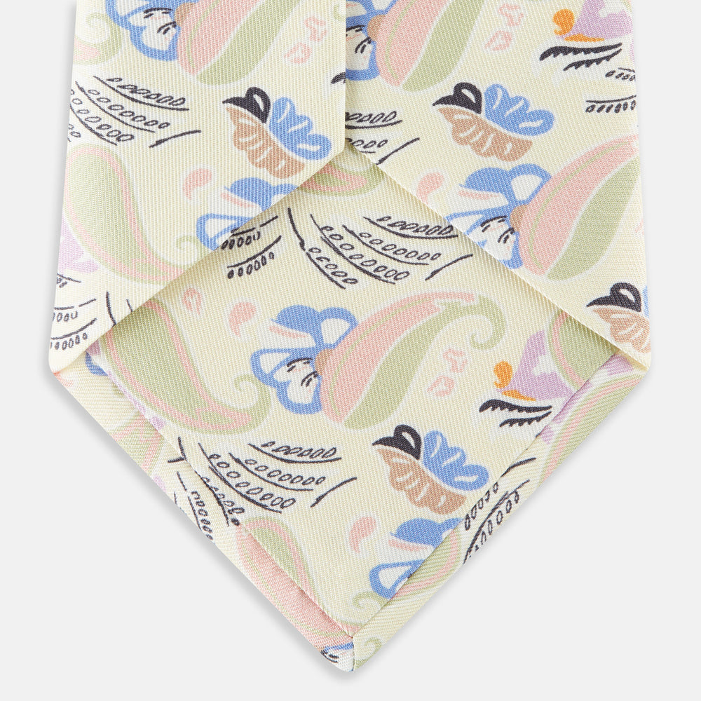 A rolled-up Cream Multi Bloomsbury-Inspired Pattern Silk Tie by Turnbull & Asser, featuring a pastel floral and paisley design in green, blue, pink, and orange tones, displayed on a white background.