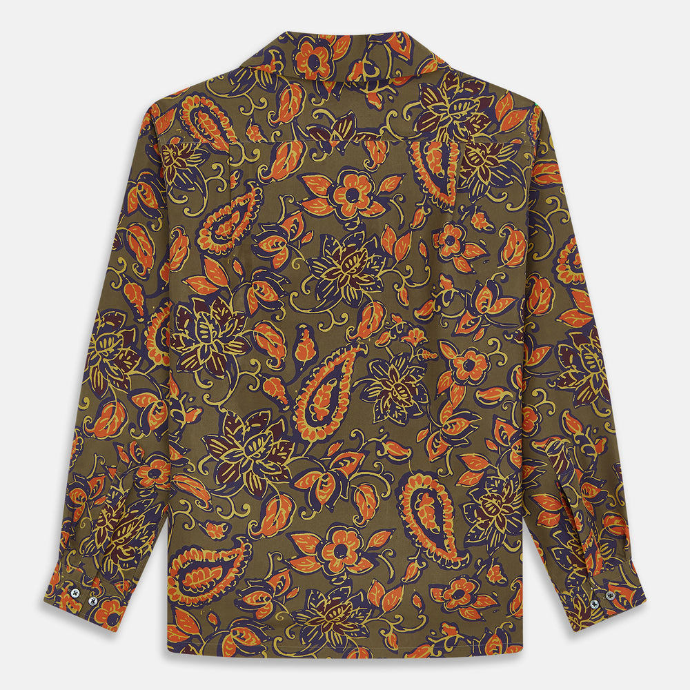 The Turnbull & Asser Khaki Green Floral Silk Holiday Fit Winnington Shirt features a bold floral print with orange, yellow, and purple on an olive background, plus a spread collar and chest pocket for versatile style.