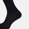 View 4 of product A single Turnbull & Asser Navy Micro Knit Long Sock is shown in a side profile against a plain white background, with the toe pointing downward and the cuff at the top.