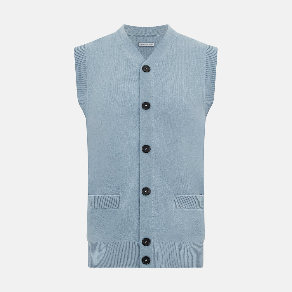 The Turnbull & Asser Frost Blue Cashmere Sleeveless Cardigan features a V-neck, five black buttons, two front pockets, and ribbed trim—ideal for layering in sophisticated outfits.