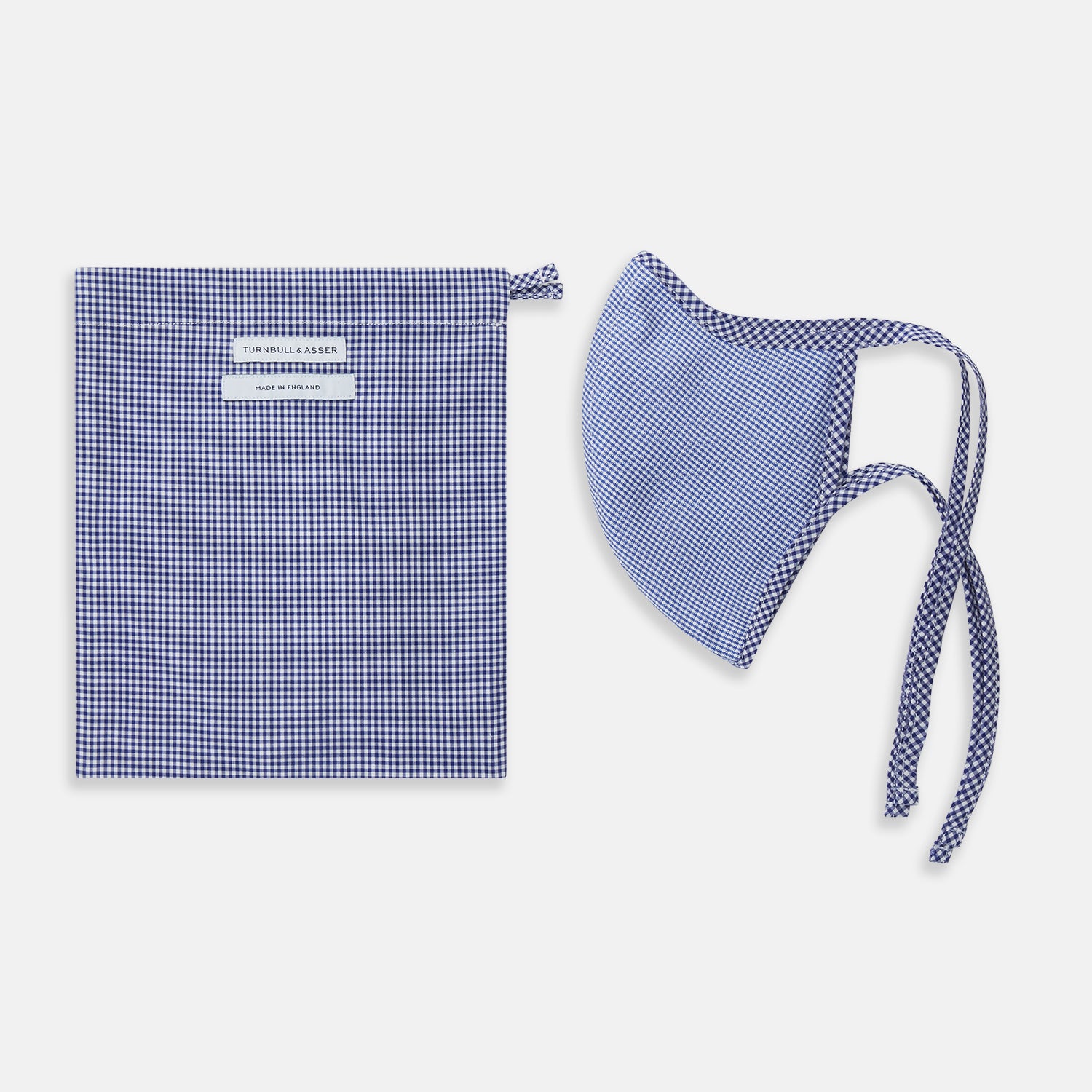 View 2 of product The Turnbull & Asser White & Navy Multi Check Commuter Mask comes with 3 Viroformula™ filters and two adjustable tie straps on each side, shown on a plain white background.