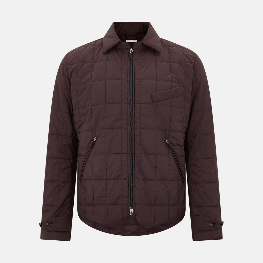 The Battersea Burgundy Quilted Jacket by Turnbull & Asser is a men's elegant outerwear featuring a front zipper, zippered side pockets, chest pocket, pointed collar, and buttoned cuffs, shown on a plain white background.
