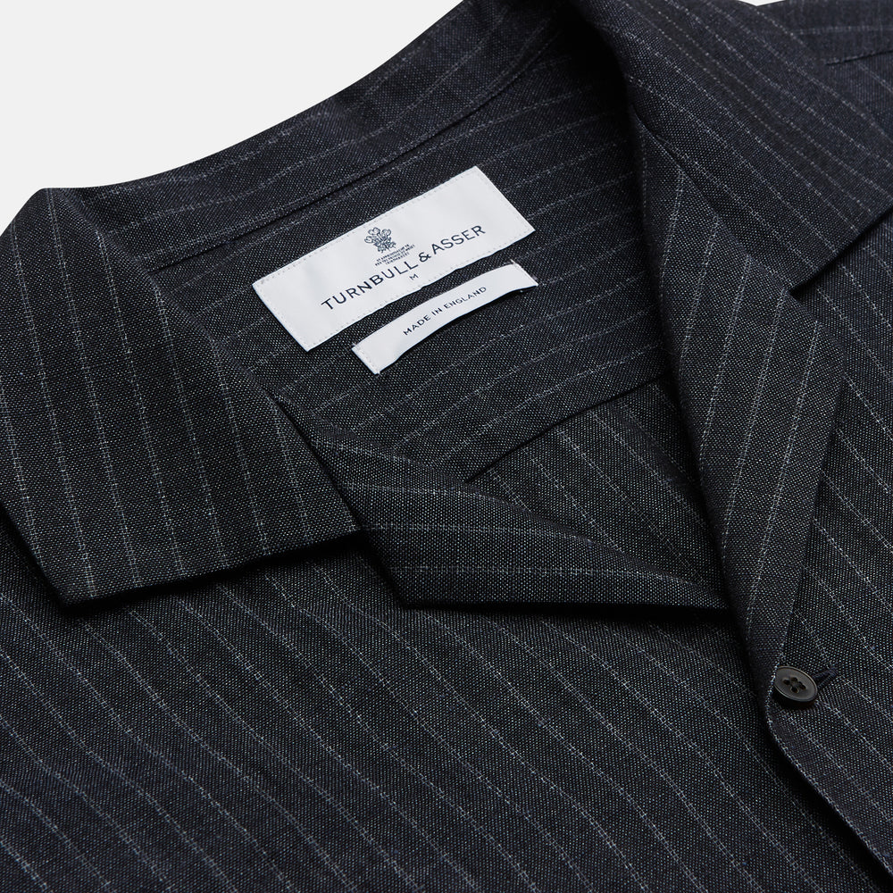 The Navy Tailored Pinstriped Shirt Jacket by Turnbull & Asser is a smart-casual, lightweight cotton-linen piece with long sleeves, a collar, left chest pocket, and front buttons for easy style.