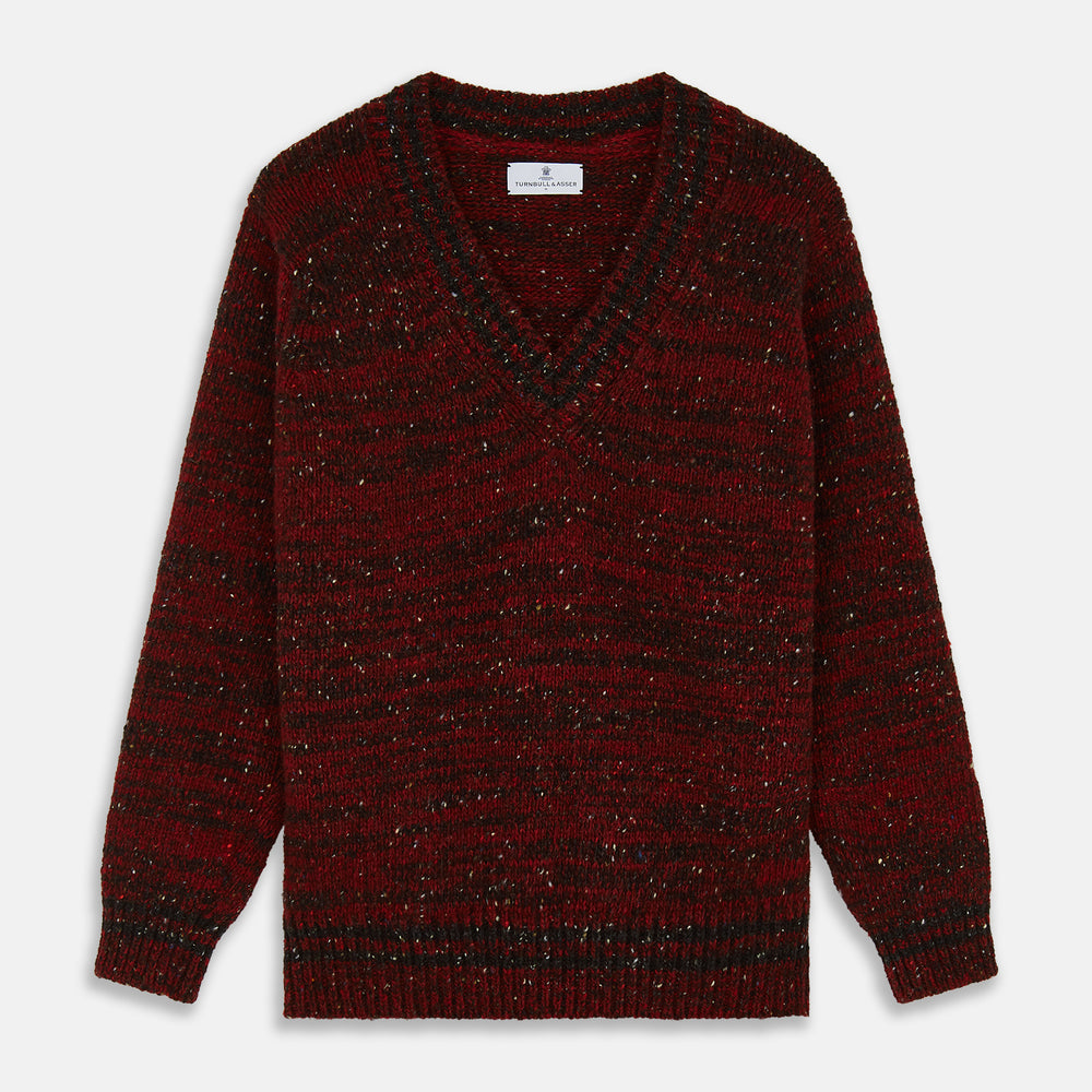 The Turnbull & Asser Russet Red Melange Wool Hafod Cricket Jumper features maroon and black speckles, a V-neck, long sleeves, and ribbed cuffs and hem, displayed flat on a white background.