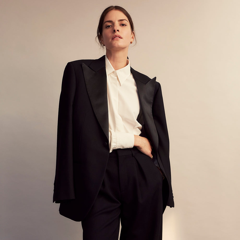 The Cream Silk Tailored Bianca Shirt by Turnbull & Asser features long sleeves, a pointed collar, and curved hem in soft-touch peace silk with a tailored fit. Shown laid flat on a white background.