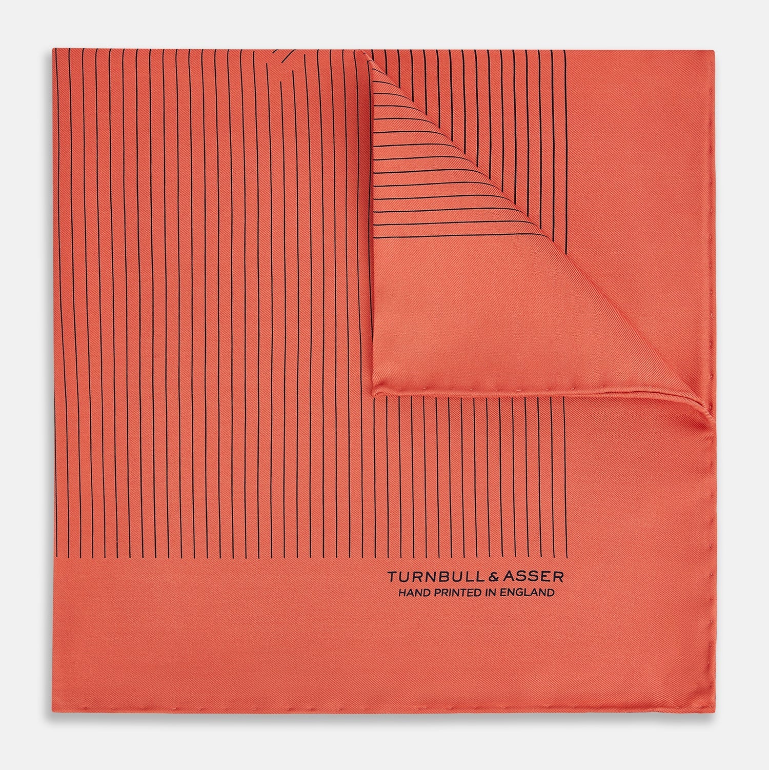 View 1 of product The Orange Stripe Silk Pocket Square by Turnbull & Asser features thin black vertical lines and "TURNBULL & ASSER HAND PRINTED IN ENGLAND" in the corner, neatly folded on a white background.