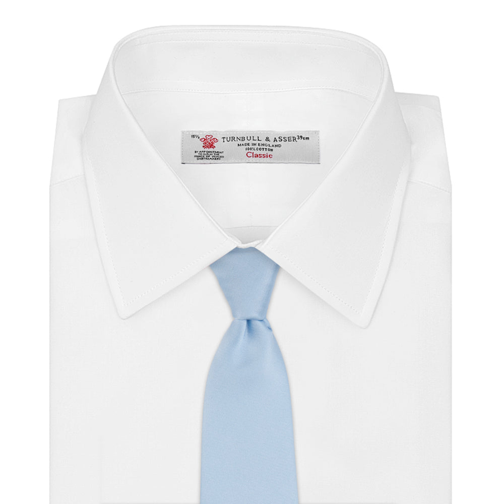 The Turnbull & Asser Plain Woven Satin Silk Tie, in light blue, is neatly rolled and displayed on a plain white background—an essential accessory for refined style.